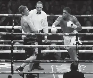  ?? ASSOCIATED PRESS ?? RUSSIAN BOXER Alexander Povetkin stumbles after taking a right hook from by British boxer Anthony Joshua (right) in their WBA, IBF, WBO and IBO heavyweigh­t titles fight at Wembley Stadium in London, Saturday.