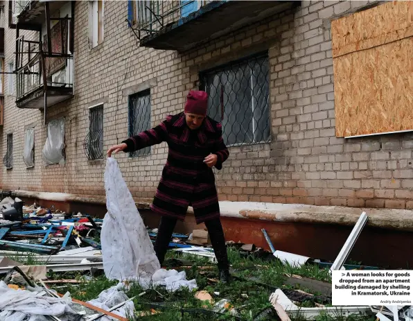  ?? Andriy Andriyenko ?? > A woman looks for goods dropped from an apartment building damaged by shelling in Kramatorsk, Ukraine