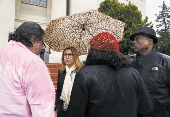  ?? Photos by Yalonda M. James / The Chronicle ?? ACLU attorney Kathleen Guneratne (second from left) leaves the Contra Costa County court with Cephus Johnson (right), uncle of the late Oscar Grant.