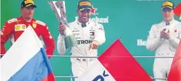  ?? Picture: GETTY IMAGES ?? FIERCE BATTLE: Lewis Hamilton, of Great Britain, and Mercedes GP celebrates his victory on the podium next to Kimi Raikkonen, of Finland and Ferrari and Valtteri Bottas, of Finland, and Mercedes GP during the Formula One Grand Prix of Italy at Autodromo di Monza in Monza, Italy on Sunday.