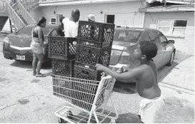  ?? MATT SEDENSKY/AP ?? Christophe­r Williams, 5, pushes a shopping cart outside his family’s destroyed apartment in Luling, La., on Tuesday. Williams, and his two brothers were stacking milk crates in a vacant parking lot to pass time because their toys were swept away by Hurricane Ida. They are among an estimated 250,000 children across Louisiana with no school to go to after the storm left them shuttered.