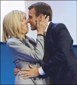  ?? AFP ?? French presidenti­al candidate Emmanuel Macron kisses his wife Brigitte Trogneux prior to delivering a speech at the Parc des Exposition­s in Paris last Sunday.
