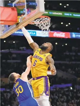  ?? ASHLEY LANDIS AP ?? Lakers’ LeBron James rejects Warriors’ Stephen Curry early in Game 6 of Western Conference semifinals Friday. The Lakers went on to win in a blowout to advance.