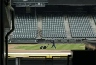  ?? TED S. WARREN — THE ASSOCIATED PRESS ?? A grounds crew worker cuts the infield in front of empty seats at T-Mobile Park in Seattle, Thursday, around the time when the first pitch would have been thrown in the Mariners’ Opening Day game .