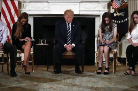  ?? CAROLYN KASTER — THE ASSOCIATED PRESS ?? President Donald Trump bows his head during an opening prayer at the start of a listening session with high school students and teachers in the State Dining Room of the White House in Washington, Wednesday.