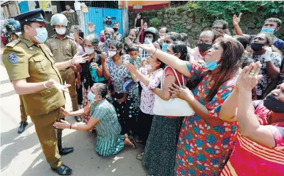  ??  ?? Family members of prisoners expressing grief to a police officer following unrest at the Mahara Prison on the outskirts of Colombo yesterday. – REUTERSPIX