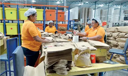  ??  ?? Mujeres elaboran bolsas personaliz­adas en Industrias Nigua (Indusnig).