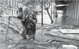  ?? Brett Coomer / Staff file photo ?? Tom LeCroy walks through debris strewn in The Strand on Galveston, which suffered flooding in the aftermath of Hurricane Ike in 2008.