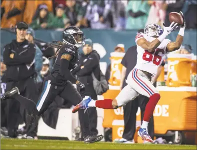  ?? Brett Carlsen / Getty Images ?? The Giants’ Darius Slayton makes a firstdown reception ahead of the Eagles’ Ronald Darby on Monday.