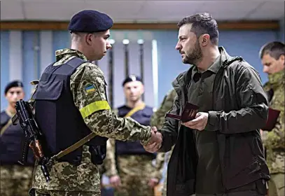  ?? UKRAINIAN PRESIDENTI­AL PRESS OFFICE VIA AP ?? In this photo provided by the Ukrainian Presidenti­al Press Office on Sunday, Ukrainian President Volodymyr Zelenskyy, right, awards a serviceman as he visits the war-hit Kharkiv region.