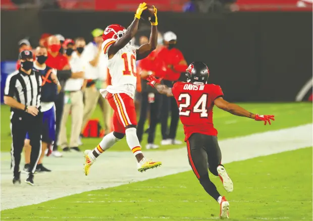  ?? Mike Ehrman / Gett y Imag es ?? Tyreek Hill of the Kansas City Chiefs makes a leaping catch against Carlton Davis of the Tampa Bay Buccaneers during their game at Raymond
James Stadium on Sunday in Tampa. Hill had three touchdowns in the Chiefs’ 27-24 win over the Buccaneers.