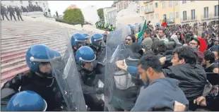  ??  ?? Protesters clash with police at the steps of the Portuguese parliament.