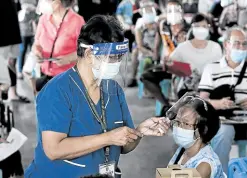 ?? —RICHARD A. REYES ?? EARLY RECIPIENTS Senior citizens in Parañaque City are inoculated with the CoronaVac vaccine at a shopping mall near Manila Bay on Friday.