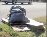  ?? (NWA Democrat-Gazette/Keith Bryant) ?? A few bags of trash and larger items are left alongside the roadway for state Transporta­tion Department crews to pick up after the highway cleanup.