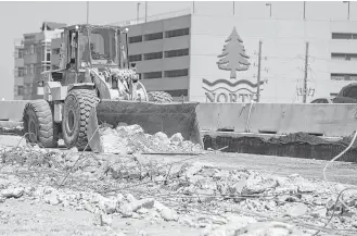  ?? Melissa Phillip / Houston Chronicle ?? Workers are tearing out the pavement of the old main lanes of U.S. 290 near where the eastbound portion of the Huffmeiste­r Road overpass was recently demolished.