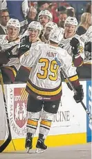  ?? | DALE WOLTMAN/ WOLVES ?? Wolves defenseman Brad Hunt is congratula­ted after his goal in the first period Sunday.