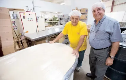  ??  ?? Desde la izquierda, Efraín Soto, quien ha trabajado con Borinquen Biscuit Corp. por 77 años, junto a Don Antonio Rodríguez Zamora, presidente de la empresa, cuya planta de manufactur­a ubica en Yauco.