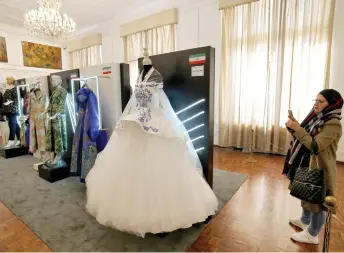  ?? — AFP photo ?? A visitor looks at creations displayed during the annual exhibition on fashion and clothes designed by young Iranian designers, at the Sadabad Palace Complex, north of the Iranian capital Tehran.