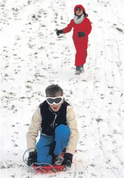  ?? Picture: Kris Miller. ?? It’s snow much fun: Zola McIntee and Stanley Reeves enjoy sledging on Dundee’s Magdalen Green.