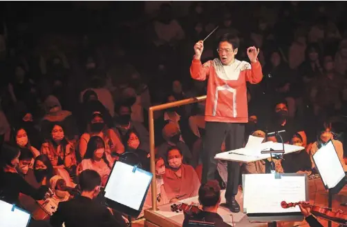  ?? — MPO ?? Naohisa – proudly wearing an ultraseven top – leading the musicians at the sold out Symphonic Anime concert series at dewan Filharmoni­k Petronas in Kuala Lumpur last weekend.
