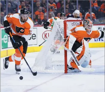  ?? CHRIS SZAGOLA — THE ASSOCIATED PRESS ?? The Flyers’ Kevin Hayes, left, brings the puck out from behind goalie Brian Elliott, right, during the third period on Saturday.