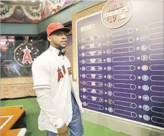  ?? Julio Cortez Associated Press ?? JORDON ADELL, who hit a national-best 25 home runs at Ballard High in Louisville, Ky., walks in front of the draft board after being selected by the Angels with the 10th overall pick.