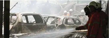 ?? PUGUH SUJIATMIKO/JAWA POS ?? BANGKAI BESI: Mobil-mobil yang terparkir di dalam stan Abdul Mukti juga terbakar. Kerugian mencapai ratusan juta rupiah.