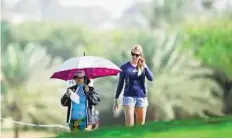  ?? Ahmed Ramzan/Gulf News ?? Sun-drenched Spectators wait for their favourite group to arrive on the final day at the Emirates Golf Club.