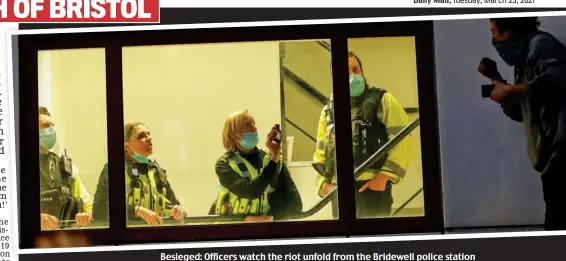  ??  ?? Besieged: Officers watch the riot unfold from the Bridewell police station