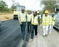 ??  ?? Housing and Infrastruc­ture Developmen­t Minister Ronald Chitotela inspectinn­g roads