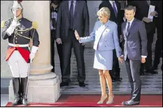  ?? NEW YORK TIMES ?? President Emmanuel Macron of France with his wife, Brigitte, at the Elysee Palace on the day of his inaugurati­on, in Paris on Sunday. Macron, 39, is the youngest president in France’s history.