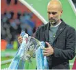  ?? FOTO: IMAGO ?? Guardiola mit Pokal und gelber Schleife unter der Jacke.