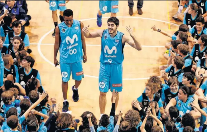  ??  ?? Adams Sola y Édgar Vicedo saludan a los canteranos del Movistar Estudiante­s durante la tradiciona­l foto de familia que se realiza en el polideport­ivo Antonio Magariños.