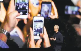  ?? Marcio Jose Sanchez / Associated Press 2016 ?? Apple fans record CEO Tim Cook’s announceme­nt of the iPhone 7 last year. The newest iteration of the iPhone has an expected starting price of $1,000.