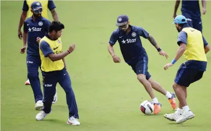  ??  ?? NAGPUR: India’s captain Virat Kohli (2R) dribbles a football past teammates during a training session ahead of the third Test cricket match between India and South Africa at The Vidarbha Cricket Associatio­n Stadium in Nagpur yesterday. — AFP