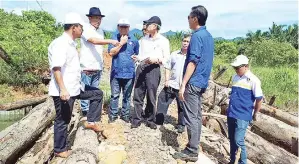  ??  ?? RONALD (dua dari kiri) bersama Michael dan Ahmad Zaki ketika meninjau jambatan Matau Patau Telupid.