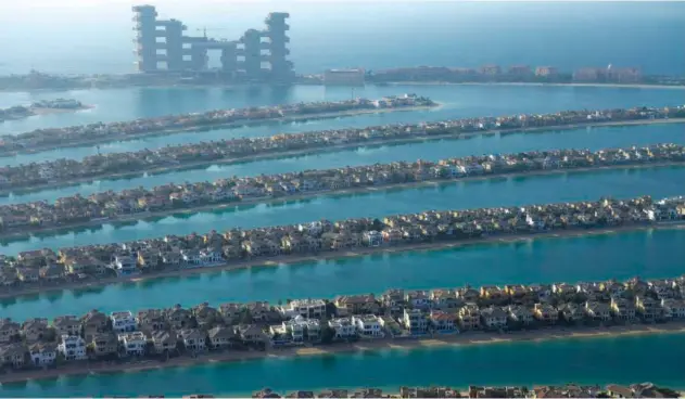  ?? Associated Press ?? ↑ The fronds of Palm Jumeirah archipelag­o stretch out across the Arabian Gulf with The Royal Atlantis Resort & Residences looming in the background in Dubai on Monday.