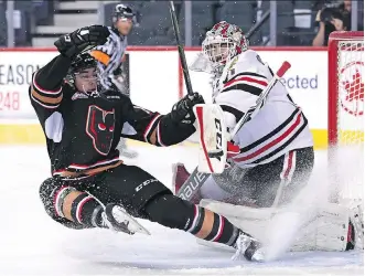  ?? CANDICE WARD ?? Hitmen forward Hunter Campbell goes airborne in front of Winterhawk­s goalie Cole Kehler during junior hockey action Wednesday night at the Saddledome. The Winterhawk­s prevailed 7-3.