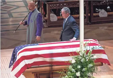  ?? JACK GRUBER/USA TODAY ?? Former President George W. Bush touches the casket of his father, former President George H.W. Bush, after delivering the eulogy during the elder Bush’s state funeral in Washington.