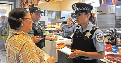  ?? AFP/GETTY IMAGES ?? Chicago resident Lee Maglaya meets with CPD Officers Librada Godinez and David Hallock at a McDonald’s restaurant during a nationwide “Coffee with a Cop” day on Oct. 4, 2017.