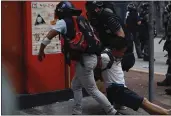  ?? GEMUNU AMARASINGH­E — THE ASSOCIATED PRESS ?? An injured anti-government protester is attended to during a clash with police in Hong Kong on Tuesday.