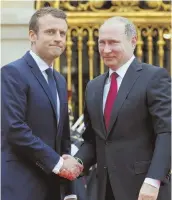  ?? AP PHOTO ?? DIPLOMACY: Russian President Vladimir Putin, right, is welcomed by French President Emmanuel Macron yesterday at the Palace of Versailles, near Paris.