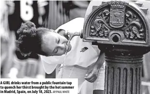  ?? AP/PAUL WHITE ?? A GIRL drinks water from a public fountain tap to quench her thirst brought by the hot summer in Madrid, Spain, on July 18, 2023.