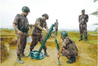  ?? (Reuters) ?? MEMBERS OF BORDER Guard Bangladesh prepare a mortar as a part their defense after heavy gunshots are being heard at the Myannmar side in Cox’s Bazar, Bangladesh, yesterday.