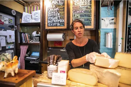  ?? Jeenah Moon, © The New York Times Co. ?? Anne Saxelby of Saxelby Cheese Mongers, organizes cheese at her shop in Manhattan on Aug. 23. Like the price of oil, silver and hogs, cheese prices are set, in part, by traders in commoditie­s markets.