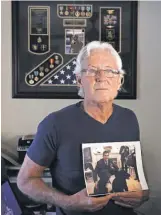  ?? EMILYMICHO­T, AP ?? William Owens holds a photo of his youngest son Navy SEAL William “Ryan” Owens in Lauderdale by the Sea, Fla.