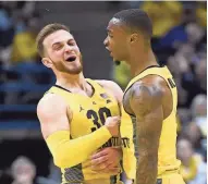  ?? BENNY SIEU / USA TODAY SPORTS MILWAUKEE JOURNAL SENTINEL ?? MU guard Andrew Rowsey (left) celebrates with Duane Wilson after Rowsey sank one of his 6 three-pointers.