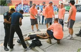  ?? JERRY JACKSON/STAFF ?? Volunteers cleaning up West Baltimore help revive one of two men who had apparently overdosed on the same block on which they were working.