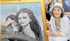  ?? ?? Italo-Tunisian actress Claudia Cardinale poses with a painting of her during the inaugurati­on of the “Claudia Cardinale” street in the city of La Goulette in Tunisian.