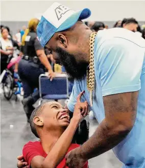  ?? Brett Coomer/Staff photograph­er ?? Trae tha Truth embraces Kanard Degrassa, 12, during Saturday’s “Special Needs” Family Day event at George R. Brown Convention Center in Houston.